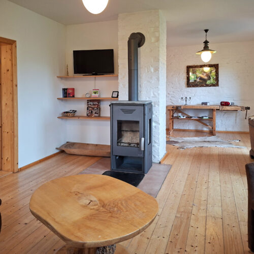 Das Bild zeigt das Wohnzimmer mit Kamin in der Erdgeschoss Ferienwohnung in der Luxusboofe in Königstein