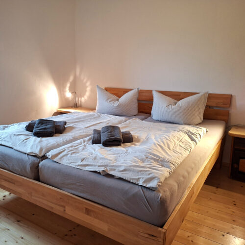 Das Bild zeigt das Doppelbett im Schlafzimmer in der Erdgeschoss Ferienwohnung in der Luxusboofe in Königstein