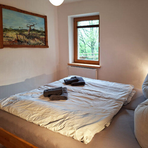Das Bild zeigt das Doppelbett im Schlafzimmer in der Erdgeschoss Ferienwohnung in der Luxusboofe in Königstein