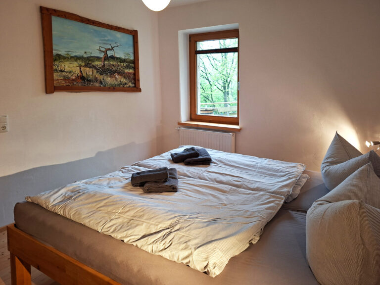 Das Bild zeigt das Doppelbett im Schlafzimmer in der Erdgeschoss Ferienwohnung in der Luxusboofe in Königstein