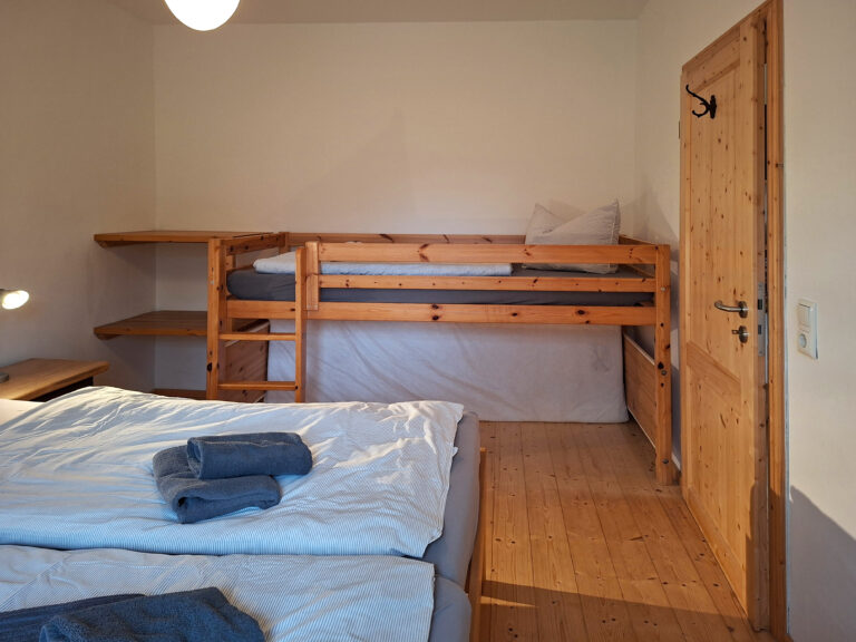Das Bild zeigt das Schlafzimmer mit 4 Schlafplätzen in der Erdgeschoss Ferienwohnung in der Luxusboofe in Königstein