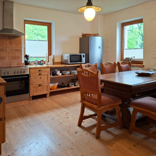 Das Bild zeigt die Küche mit Esstisch in der Erdgeschoss Ferienwohnung in der Luxusboofe in Königstein