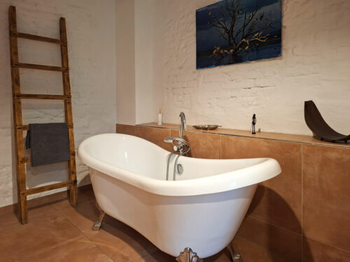 Das Bild zeigt das Bad mit freistehender Wanne in der Erdgeschoss Ferienwohnung in der Luxusboofe in Königstein