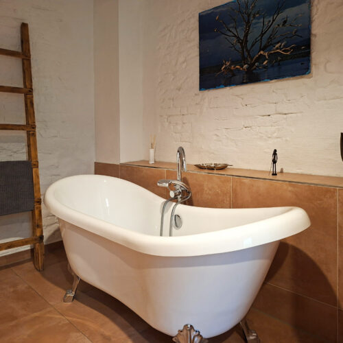Das Bild zeigt das Bad mit freistehender Wanne in der Erdgeschoss Ferienwohnung in der Luxusboofe in Königstein