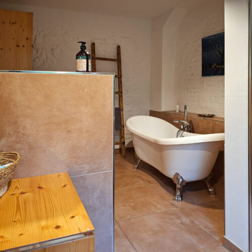 Das Bild zeigt das Bad mit freistehender Wanne und Dusche in der Erdgeschoss Ferienwohnung in der Luxusboofe in Königstein