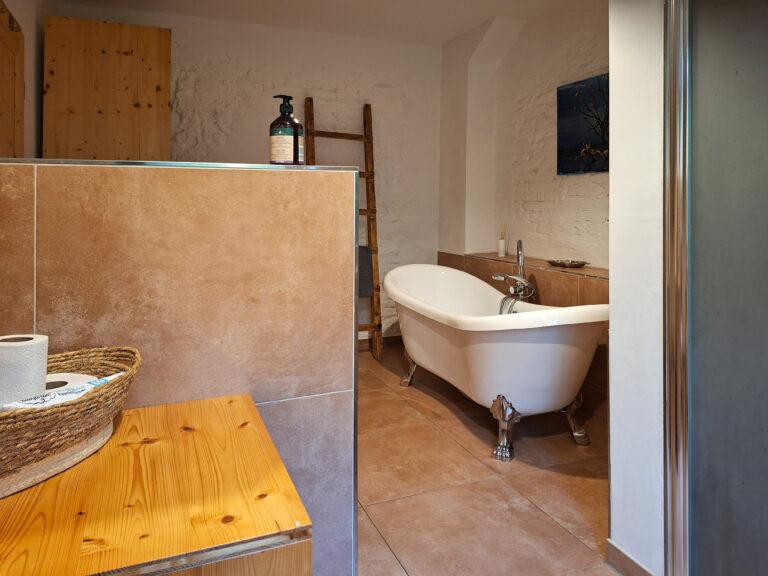 Das Bild zeigt das Bad mit freistehender Wanne und Dusche in der Erdgeschoss Ferienwohnung in der Luxusboofe in Königstein