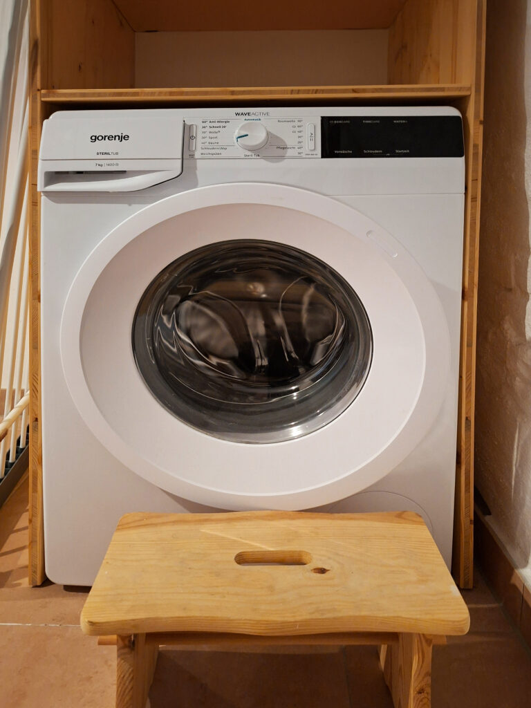 Das Bild zeigt die Waschmaschine im Bad in der Erdgeschoss Ferienwohnung in der Luxusboofe in Königstein