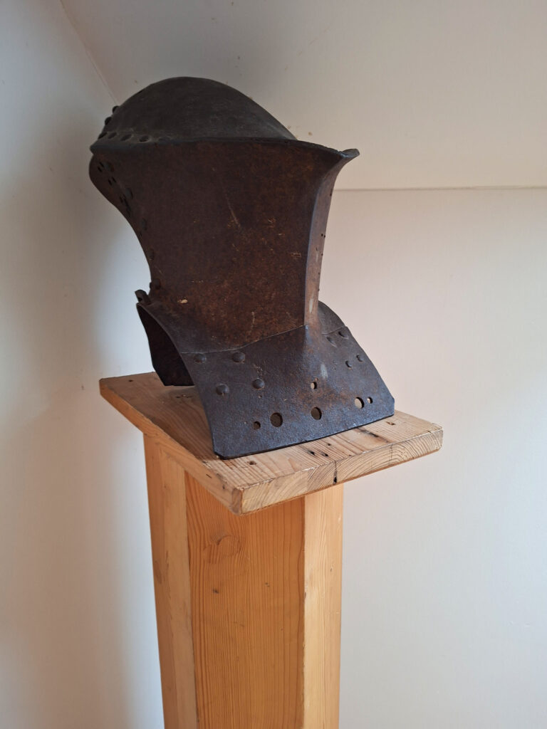 Das Bild zeigt einen alten Ritterhelm, der zur Deko in der Obergeschoss Ferienwohnung in der Luxusboofe in Königstein steht