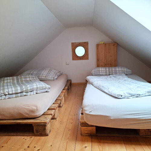 Das Bild zeigt das 4-Bett Schlafzimmer im Dach der Obergeschoss Ferienwohnung in der Luxusboofe in Königstein