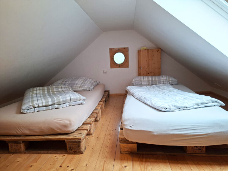 Das Bild zeigt das 4-Bett Schlafzimmer im Dach der Obergeschoss Ferienwohnung in der Luxusboofe in Königstein