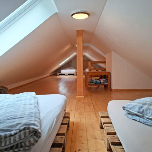 Das Bild zeigt das 4-Bett Schlafzimmer im Dach der Obergeschoss Ferienwohnung in der Luxusboofe in Königstein