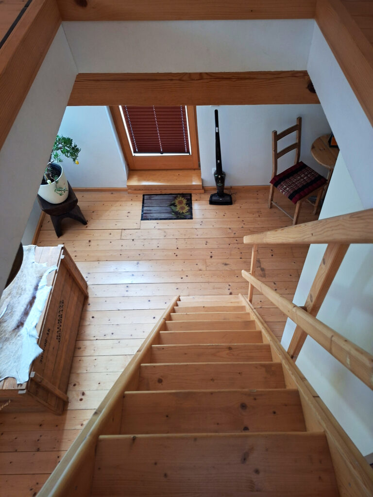 Das Bild zeigt den Abgang vom Dachgeschoss zum Wohnzimmer in der Obergeschoss Ferienwohnung in der Luxusboofe in Königstein