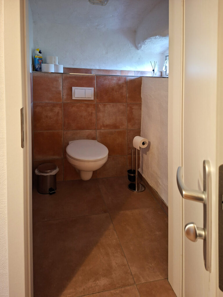Das Bild zeigt das WC im Bad in der Untergeschoss Ferienwohnung in der Luxusboofe in Königstein